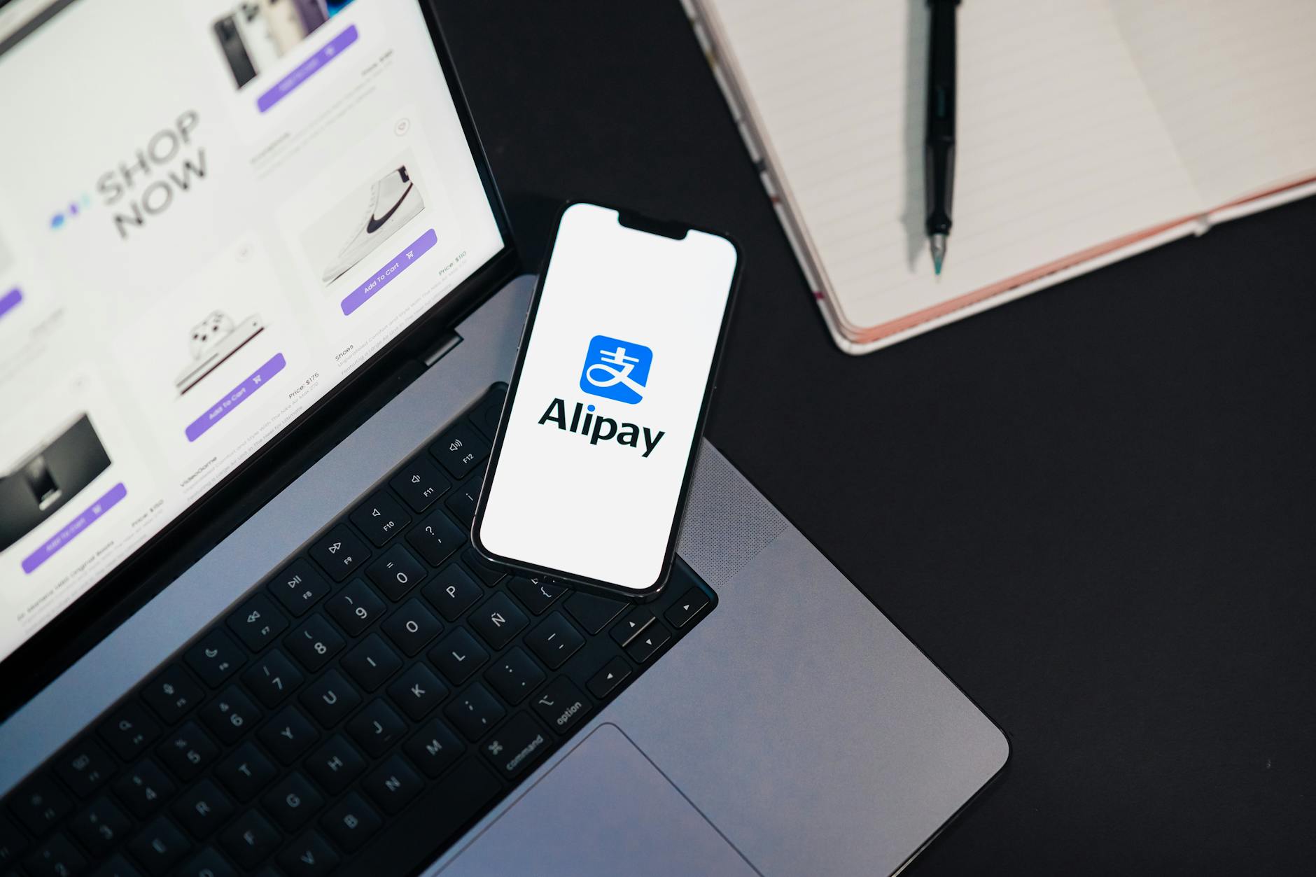alipay mobile app on smartphone with laptop