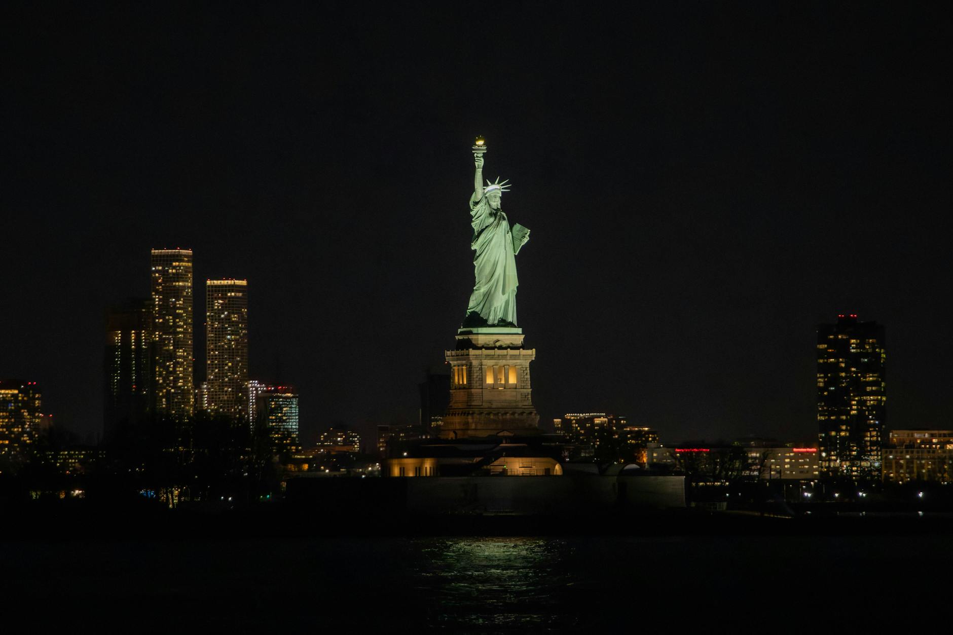 night view of the statue of liberty and skyline
