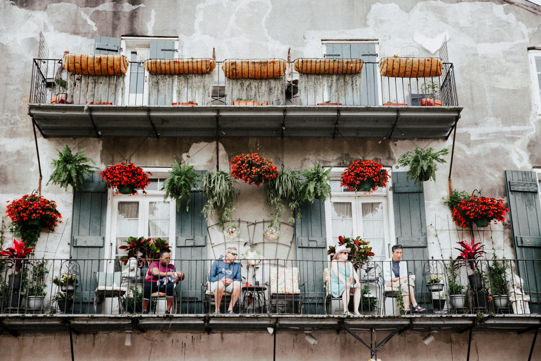people sitting on the balcony of a building in the french quarter in new orleans louisiana
