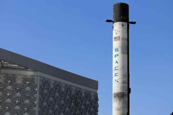 space x rocket and building exterior against blue sky
