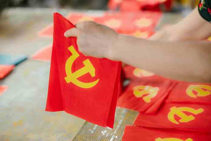 a person is holding a red communist flag