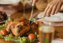 The Rich History of Thanksgiving Day a person holding stainless steel fork and knife slicing cooked meat