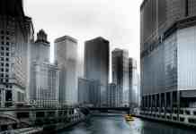 photo of boat going through river in between highrise buildings