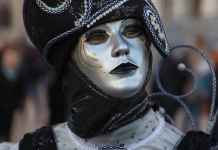The Enchanting History of the Venice Carnival a person in a mask and costume at the venice carnival