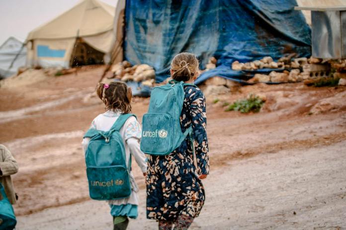 pexels-photo-7238316 photograph of children with blue backpacks walking