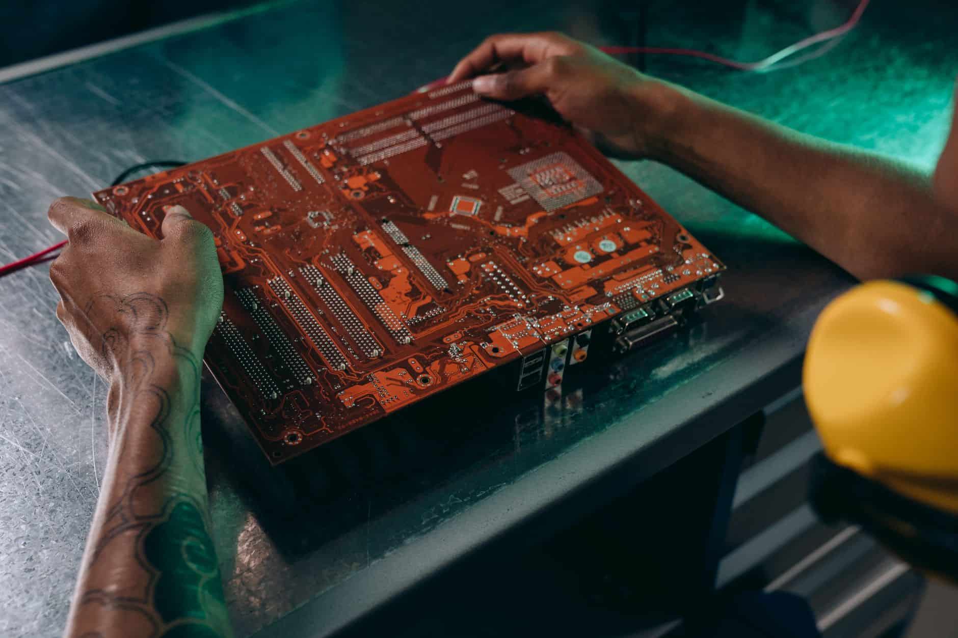 close up photo of motherboard being fixed by a person